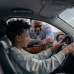 man in blue and white striped dress shirt sitting on car seat, boost productivity for Driving Instructor Owners and Managers.